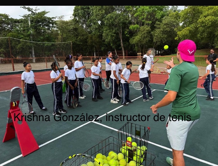 Instructor se dirige a un grupo de participantes junto a un carrito de pelotas.