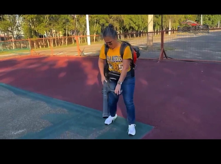 Jugador sostiene una raqueta en una cancha de tenis al aire libre.