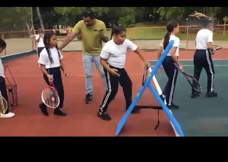 Participantes realizan un ejercicio con material de entrenamiento en la cancha.